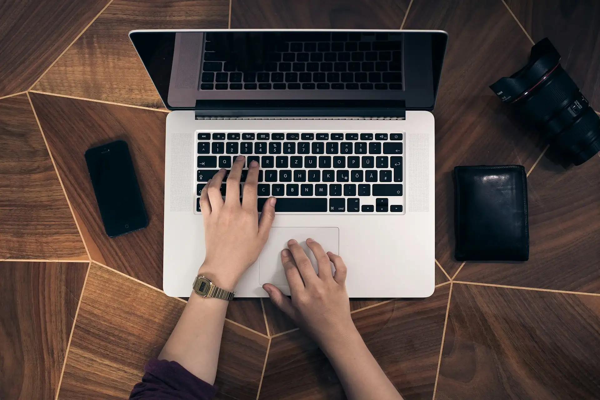 A pair of hands, illuminated by the glow of a computer screen, skillfully type on a sleek keyboard. The fingers move with precision and speed across the keys, suggesting focused activity. The keyboard is contemporary in design, with clear, distinct keys. The background is blurred, emphasizing the act of typing. The image evokes a sense of productivity and engagement with technology.